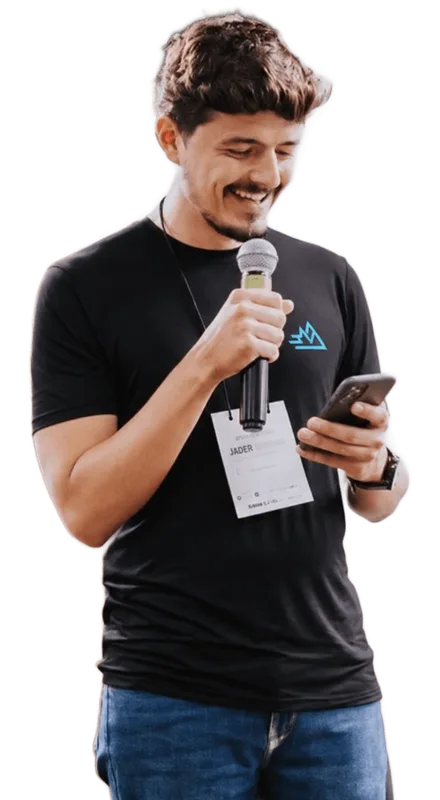 Rhavi, CEO do Grupo Escalar, falando ao microfone com o celular na mão