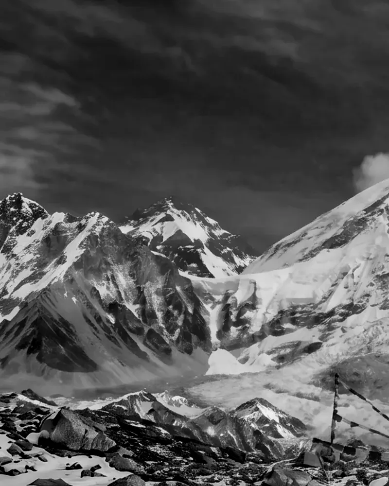 Vale glacial cercado por picos nevados, em preto e branco